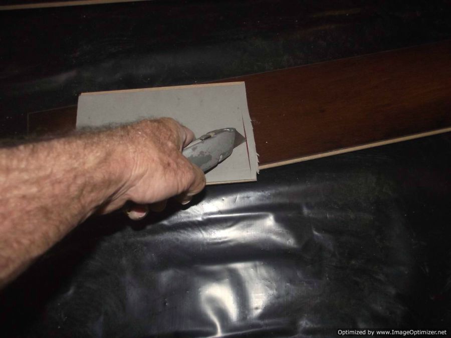 Lamton Virginia walnut laminate flooring, excess padding Being cut on back