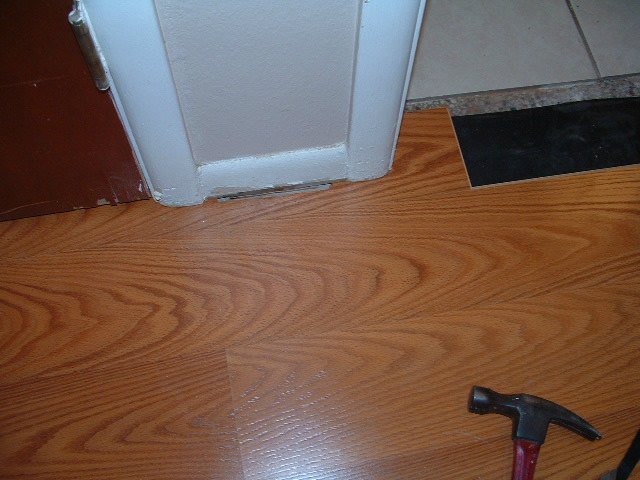 Hallways, the final result is getting this last laminate plank installed under the door jamb in the hallway.
