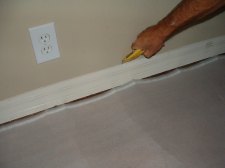 Here I am cutting the top of the baseboard where the caulking is so I can remove the old baseboard 