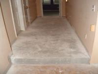 The concrete floor in the hallway after removing the carpet and padding.