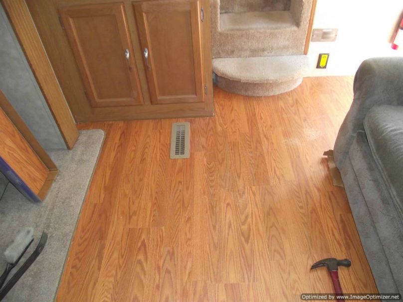 Installing laminate flooring in a travel trailer, slide laminate under the step 