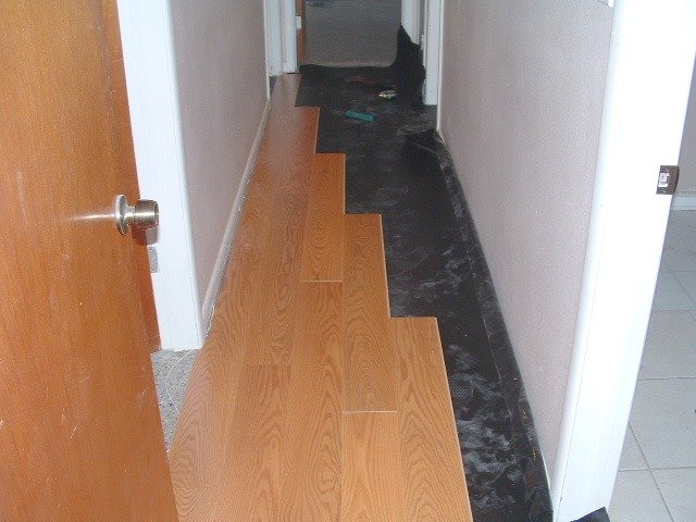 Installing laminate in hallway on the first side.