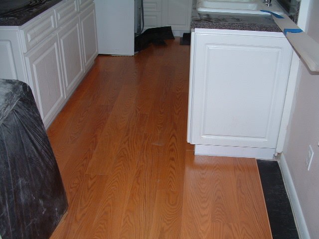 Quick step Eligna laminate flooring single board design being installed in the kitchen