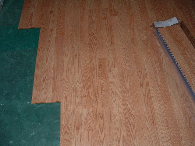 Installing Pergo Accolade laminate flooring over moisture barrier.