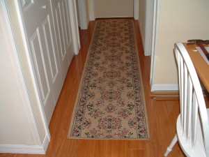 Vanier laminate flooring installed in hallway with throw rug photo