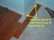 Cutting laminate around corners is easier when I install this temporary plank.