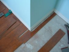 Cutting laminate around corners is easier when I install this temporary plank.
