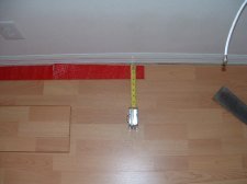 Installing the last row of laminate flooring, first measure one end.