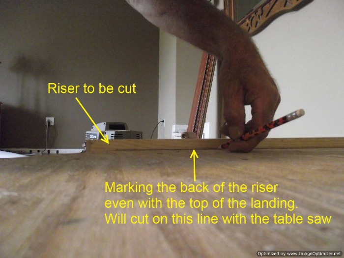 Installing laminate flooring on angled stairs, marking the back of the riser so it can be cut flush at the top of the step for the stair nose.