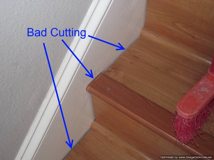 Bad laminate stair installation. It shows gaps where the treads and risers were cut, and how the stair nose was cut short and filled in with a small piece.
