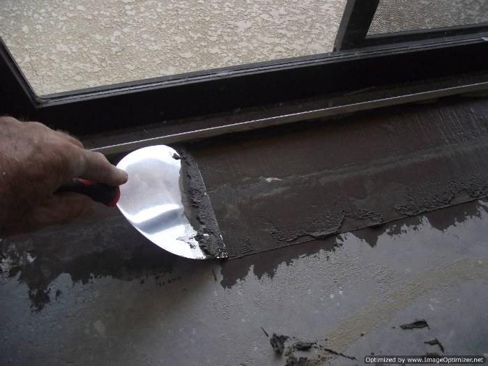 Sliding glass doors need preparation for laminate flooring installation, the straight edge shows the dip in the floor.