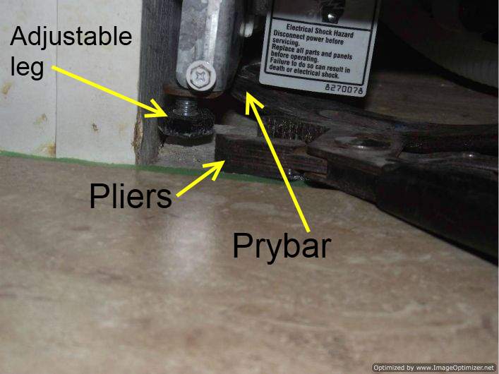 Laminate tile flooring under a dishwasher, adjusting the legs.
